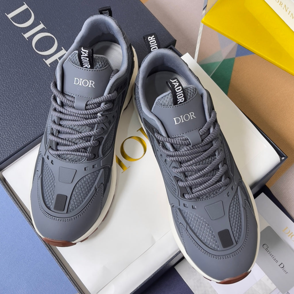 Unisex Dior lace-up sneakers with gray-blue uppers, branded tongue, and thick sole.