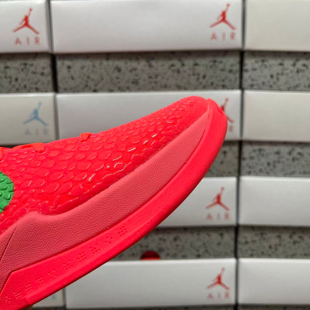 Close-up of red textured sneaker upper with green accent and curved collar