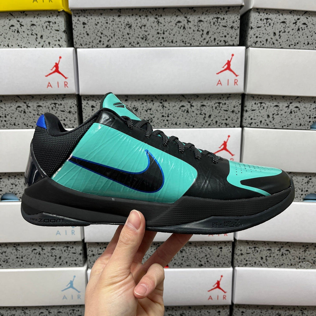 Black and teal basketball shoe with blue swoosh and black lace-up upper.