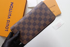 Louis Vuitton small bag with Damier check canvas and curved zip opening.