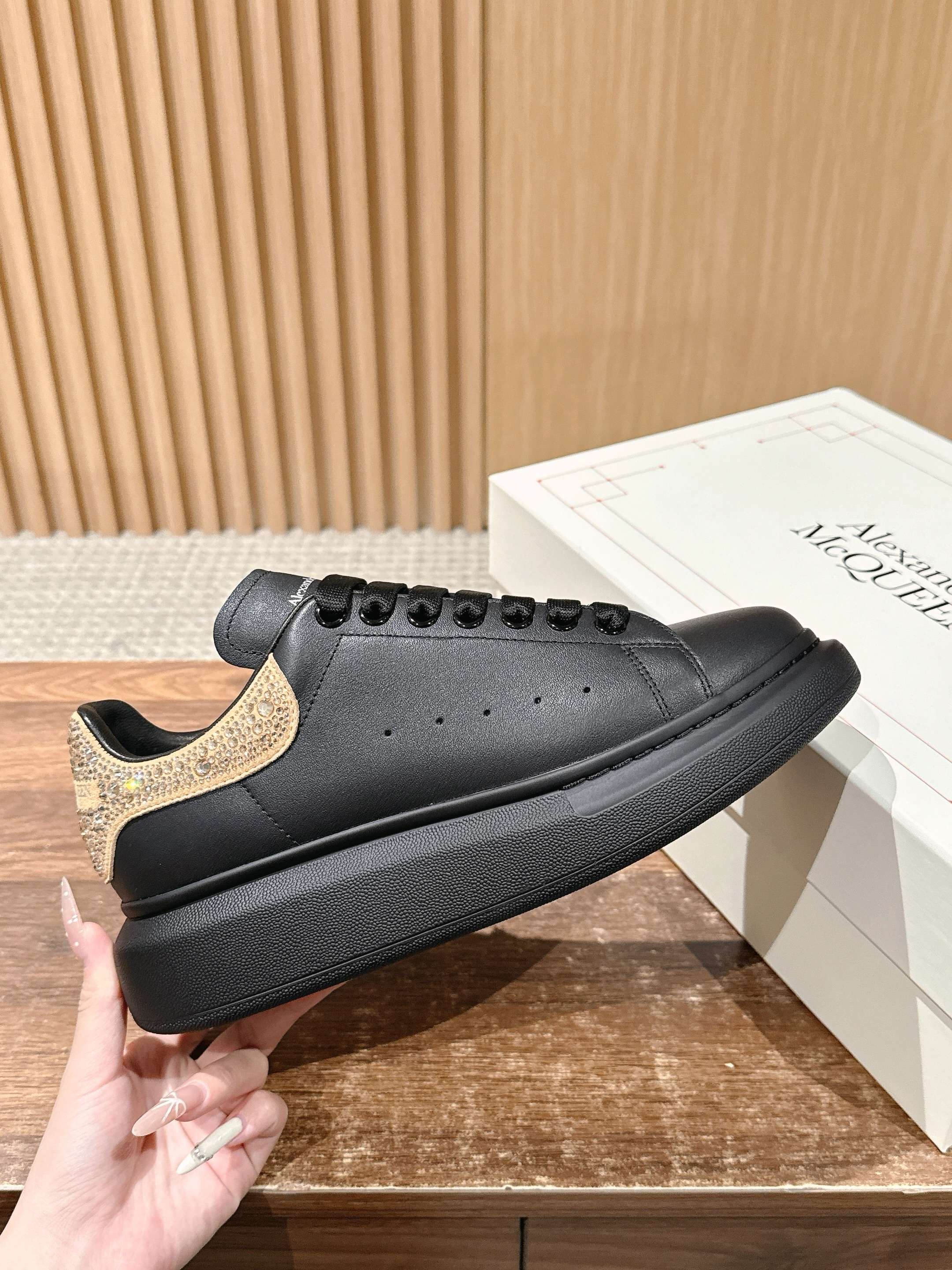 Black leather lace-up sneakers with gold glitter side panel and textured sole