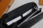 Small Louis Vuitton zip wallet open, showing card slots and inner black lining.
