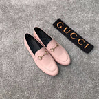 Pink Gucci loafers with gold-tone bit hardware, angled view, rounded toe slip-on