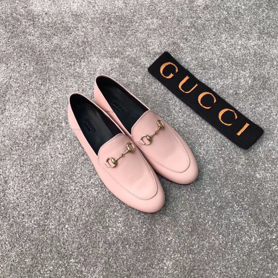Pink Gucci loafers with gold-tone bit hardware, angled view, rounded toe slip-on