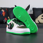 Air Force 1 sneakers, white with green laces and panel; green tread sole visible.
