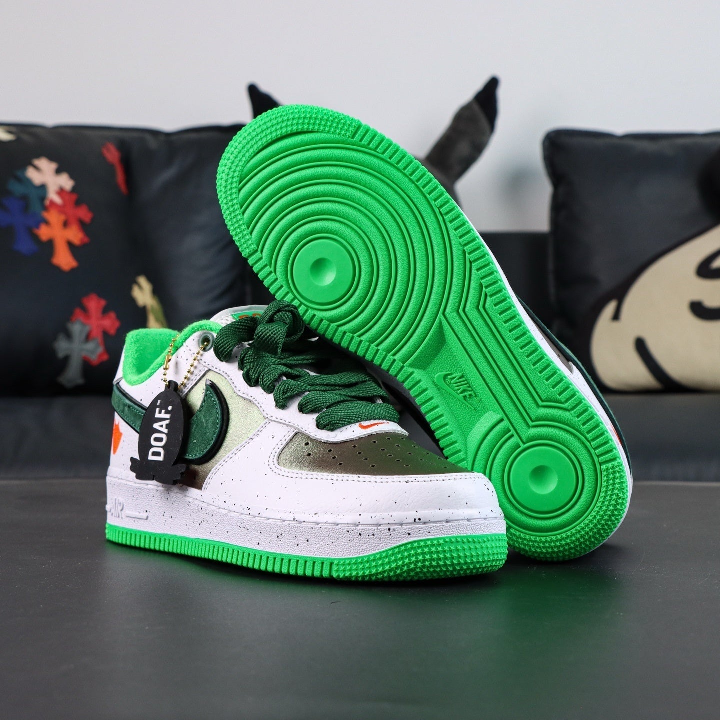 Air Force 1 sneakers, white with green laces and panel; green tread sole visible.