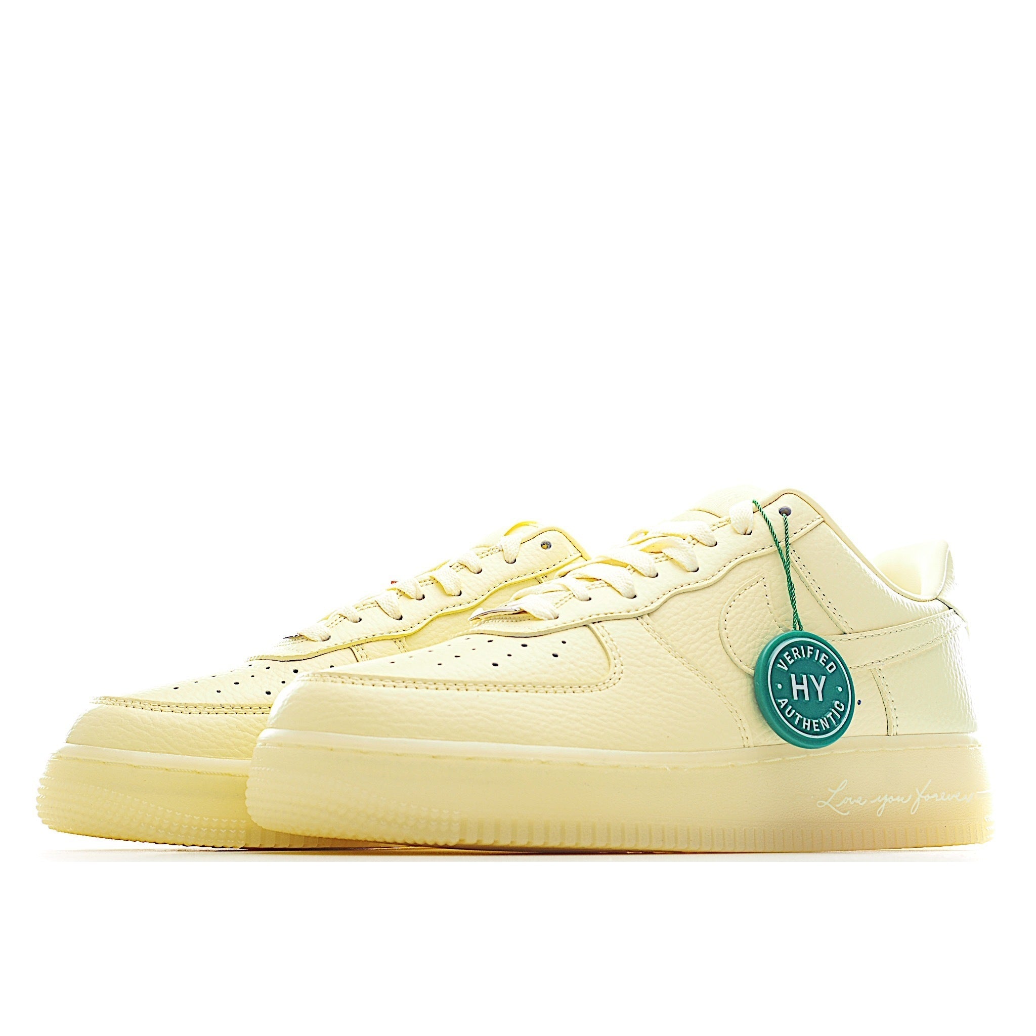 Air Force 1 low-top sneaker in pale yellow leather, side view with green laces and tag
