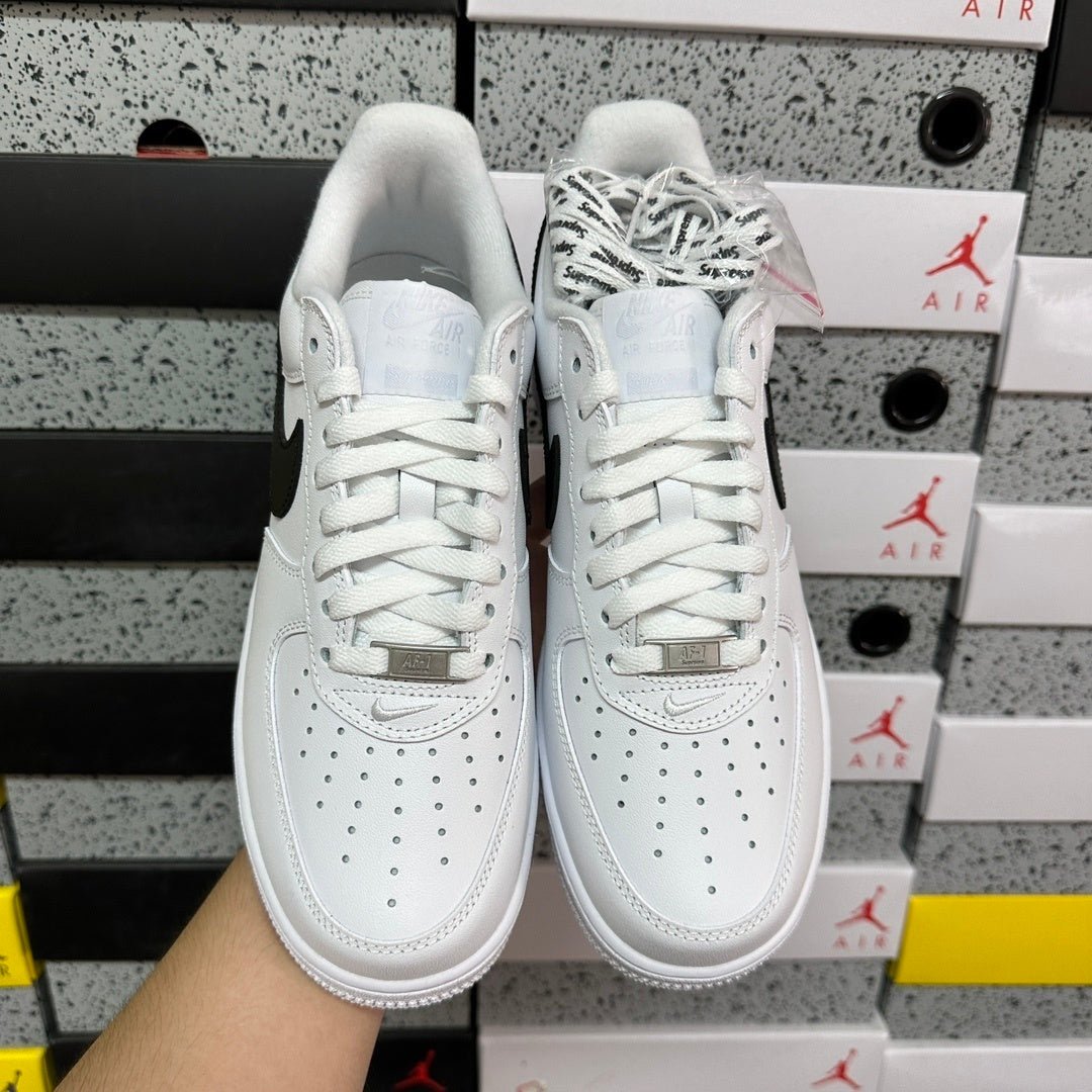 White low-top sneakers with lace-up front and Air branding on tongue, front view