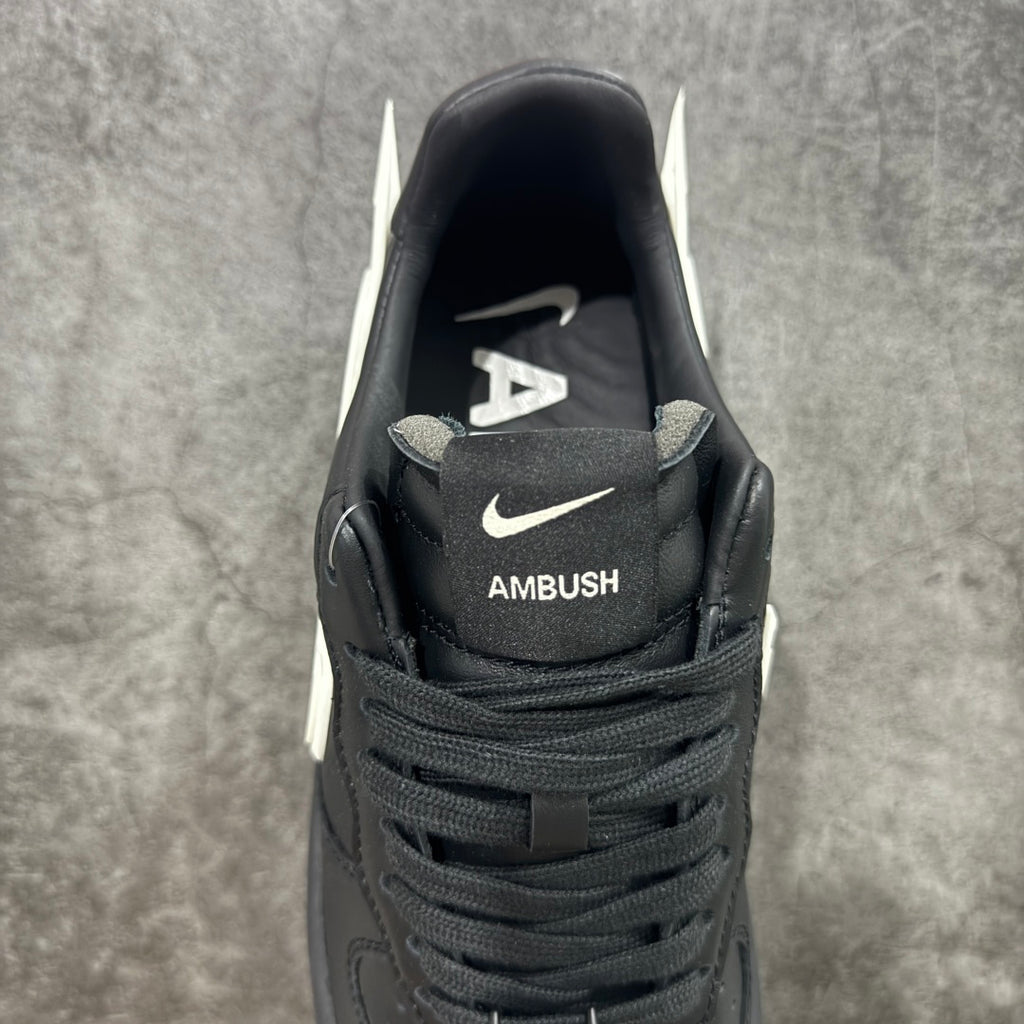 Black low-top sneakers with AMBUSH logo on the tongue and Nike swoosh near collar