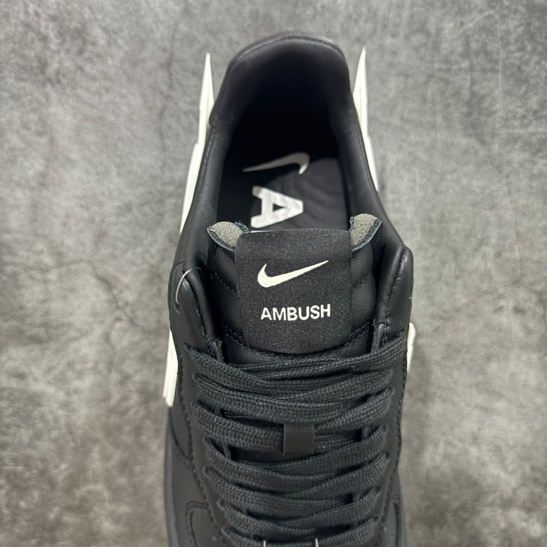 Black low-top sneakers with AMBUSH logo on the tongue and Nike swoosh near collar