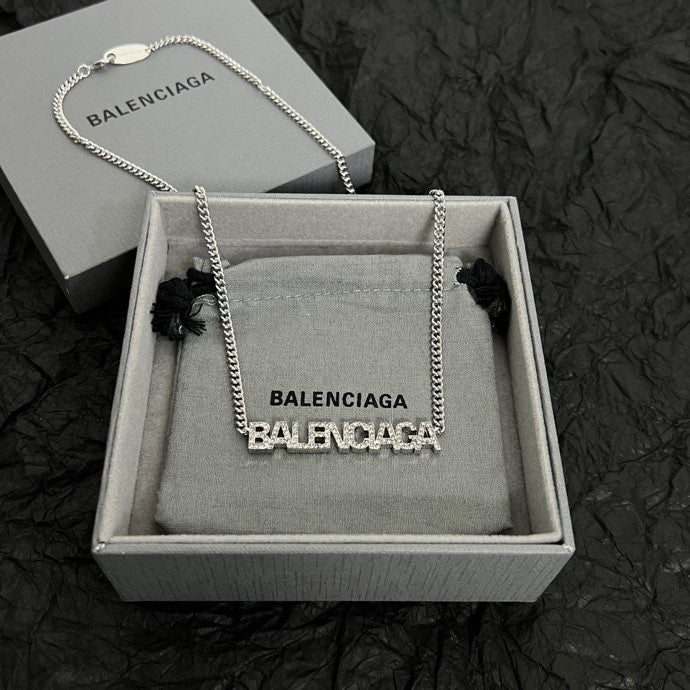 Silver Balenciaga logo pendant necklace shown in a gray box