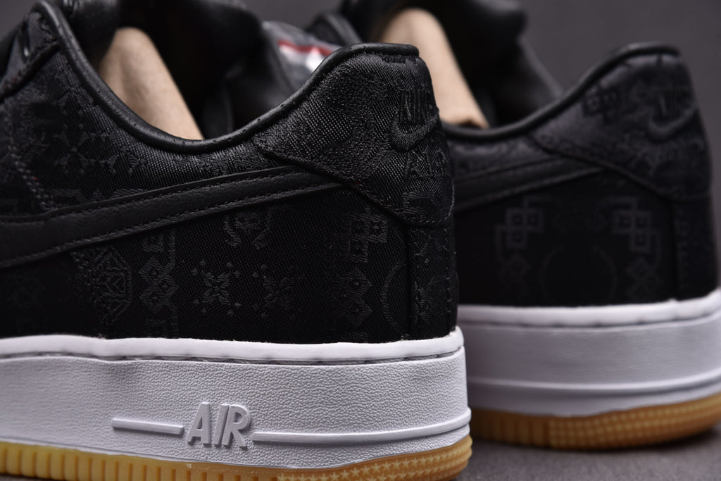 Black low-top sneakers with white midsole AIR text and gum outsole