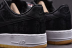 Black low-top sneakers with white midsole AIR text and gum outsole