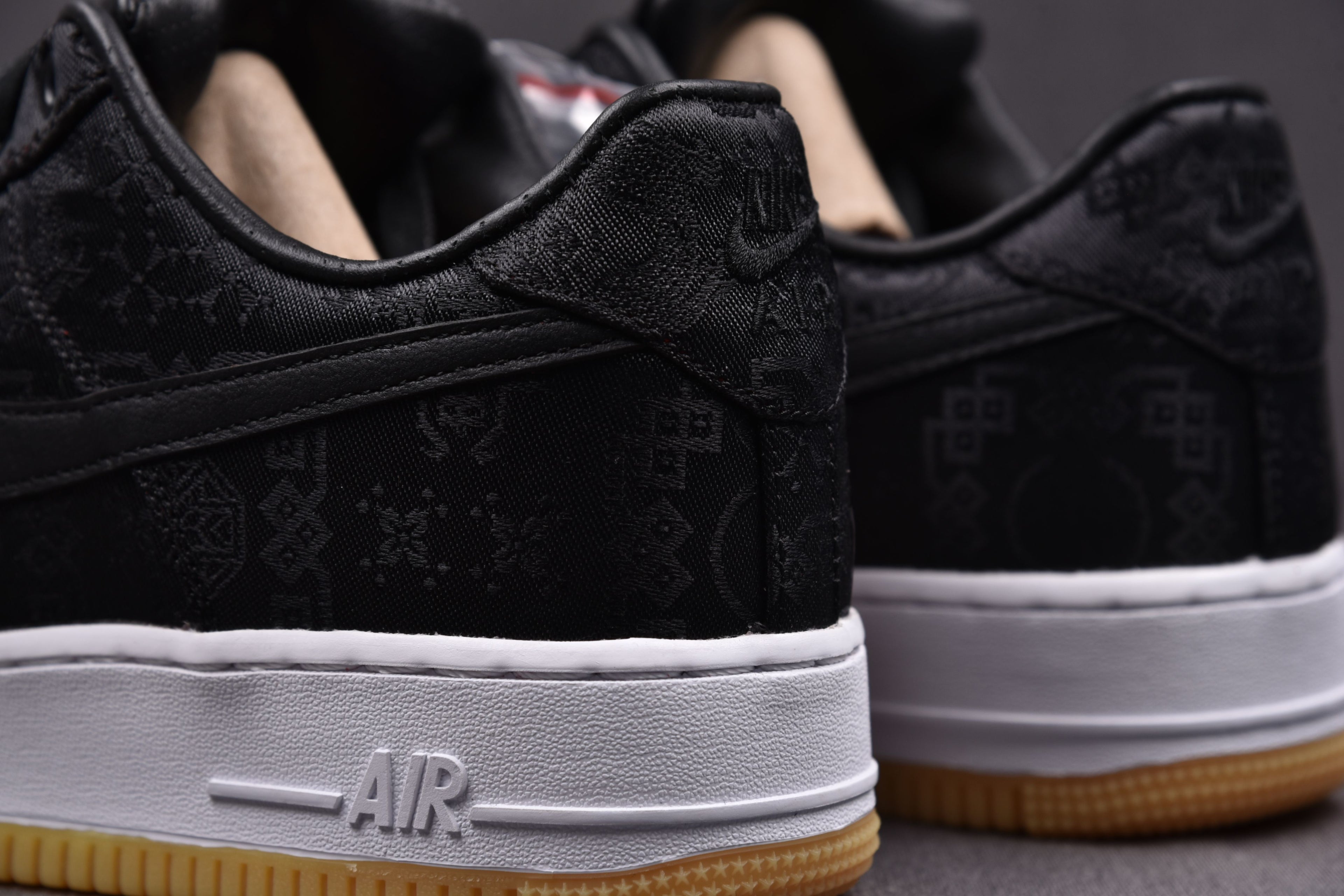 Black low-top sneakers with white midsole AIR text and gum outsole