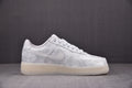 White low-top sneakers side view with swoosh and embossed pattern