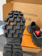 Black sneaker outsole with deep lugs and red LV heart logo on side