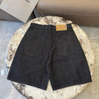 Dark denim shorts with two front pockets, center seam, and waist label