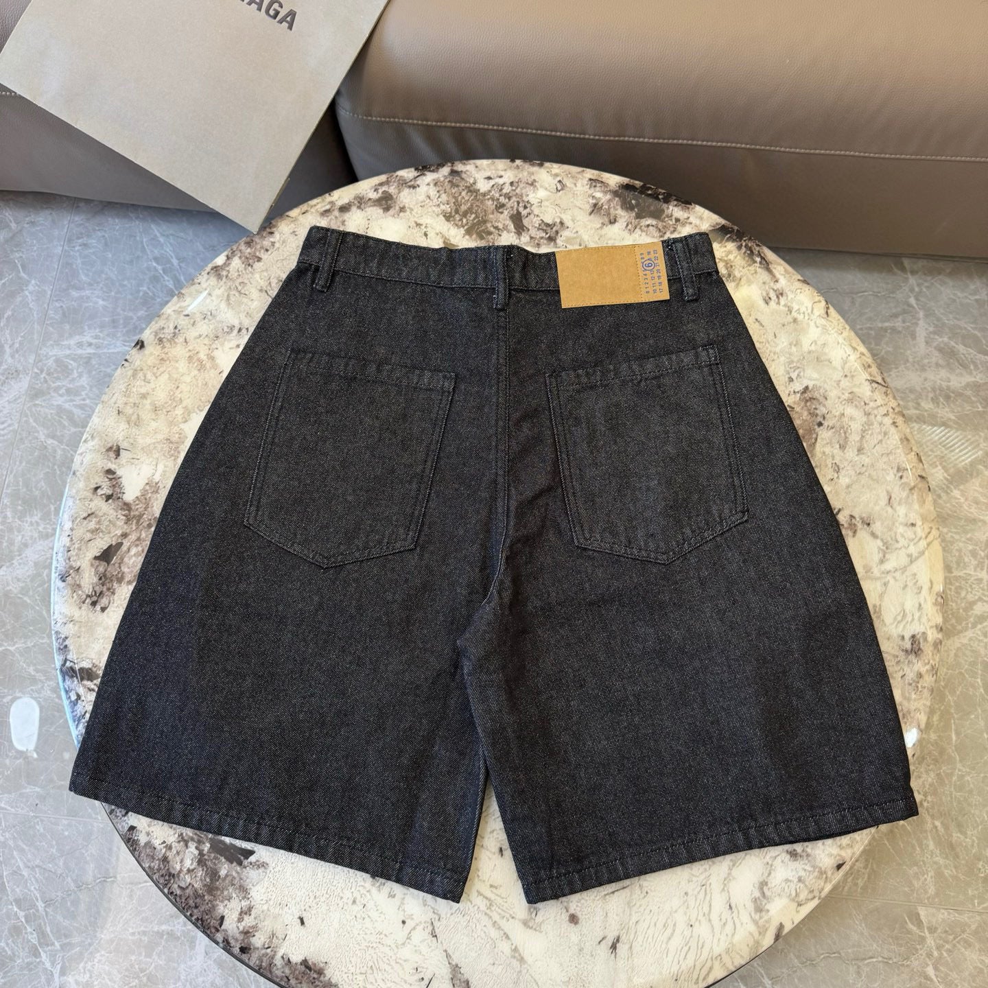 Dark denim shorts with two front pockets, center seam, and waist label