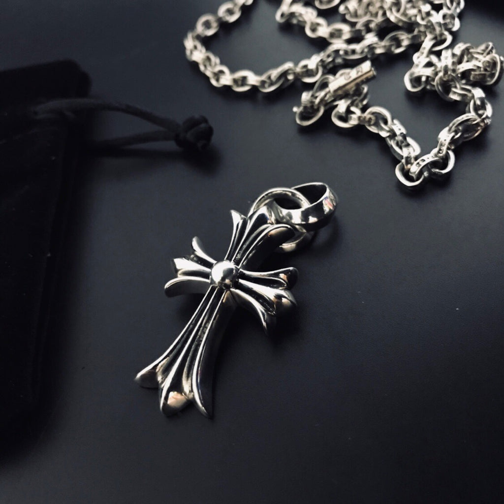 Silver cross pendant necklace detail with linked chain and clasp loop