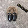 Gucci black slip-on shoes with faux fur trim and gold bit hardware