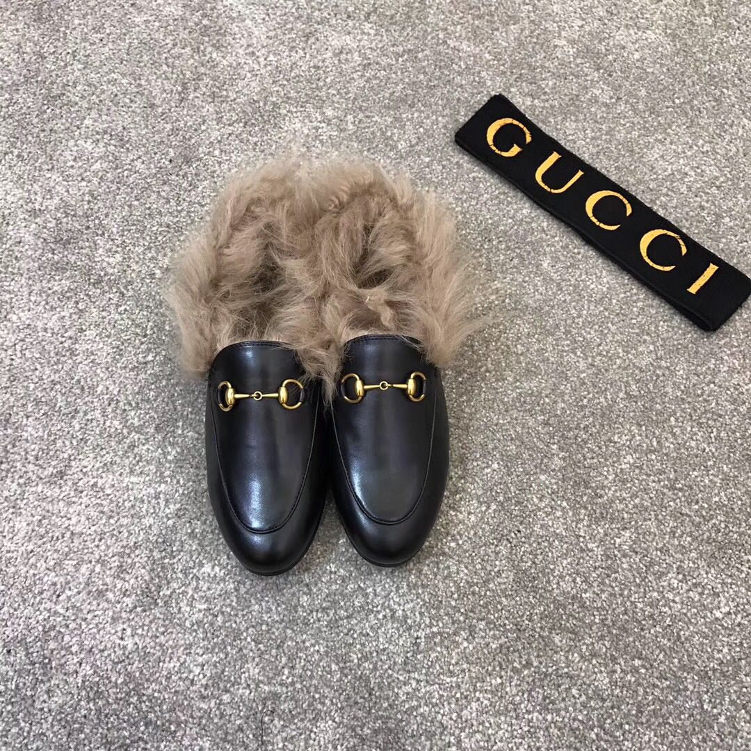 Gucci black slip-on shoes with faux fur trim and gold bit hardware