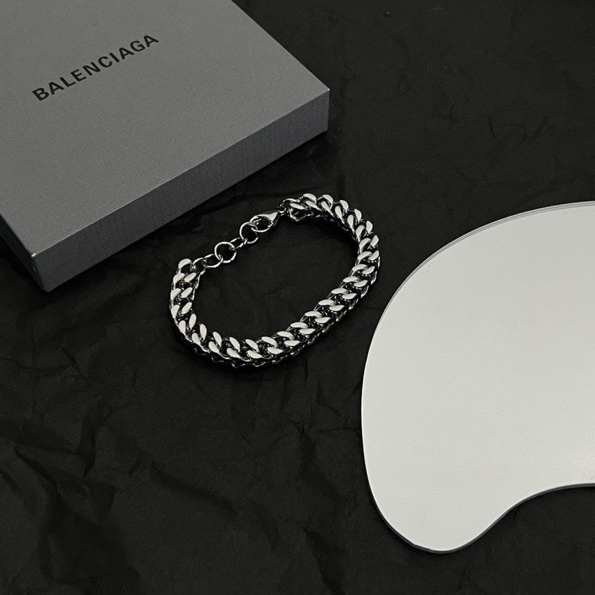 Silver chain bracelet with interlocking ring clasp and link design on black cloth