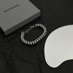 Silver chain bracelet with interlocking ring clasp and link design on black cloth