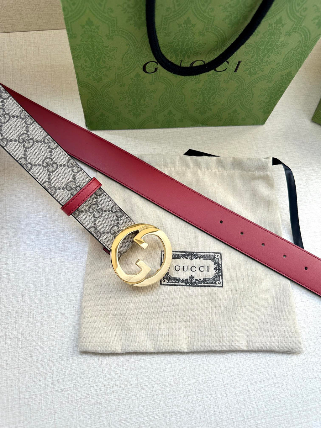 Gucci GG canvas belt with gold G buckle and red leather strap
