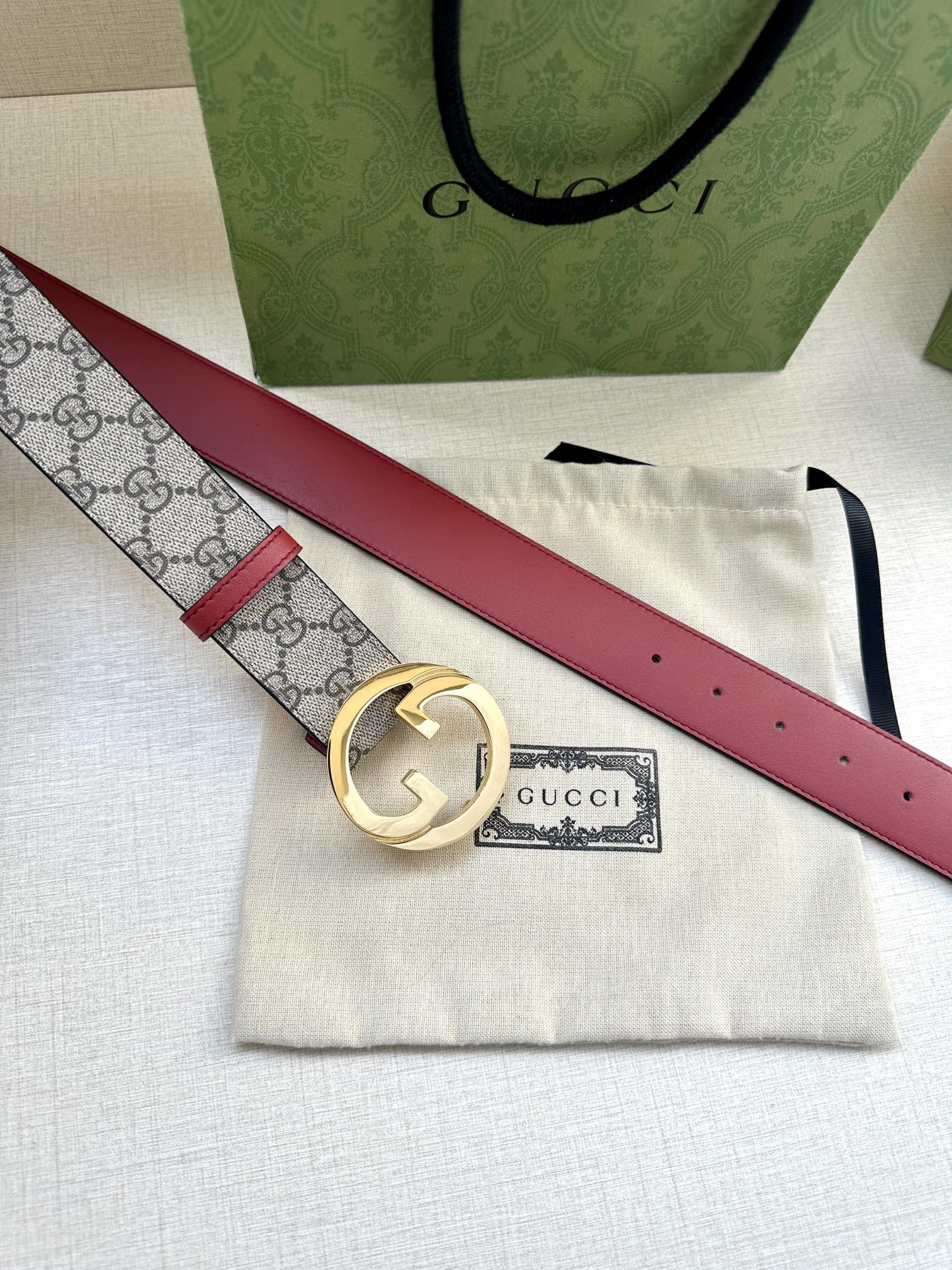 Gucci GG canvas belt with gold G buckle and red leather strap