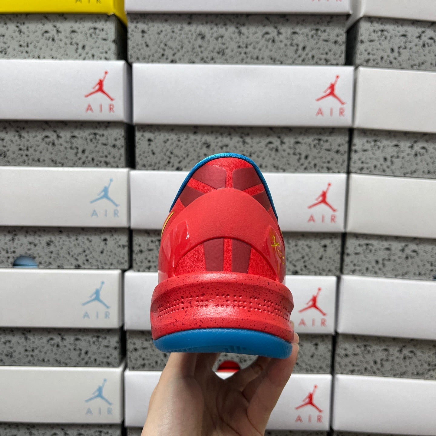 Red sneaker heel and toe with blue midsole and textured outsole.