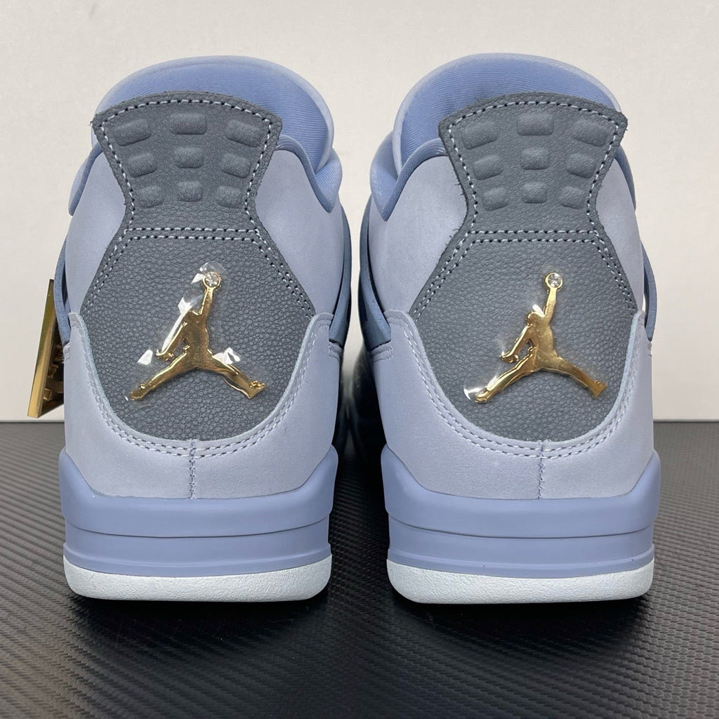 Pair of light blue Air Jordan 4 sneakers with gold Jumpman on heel
