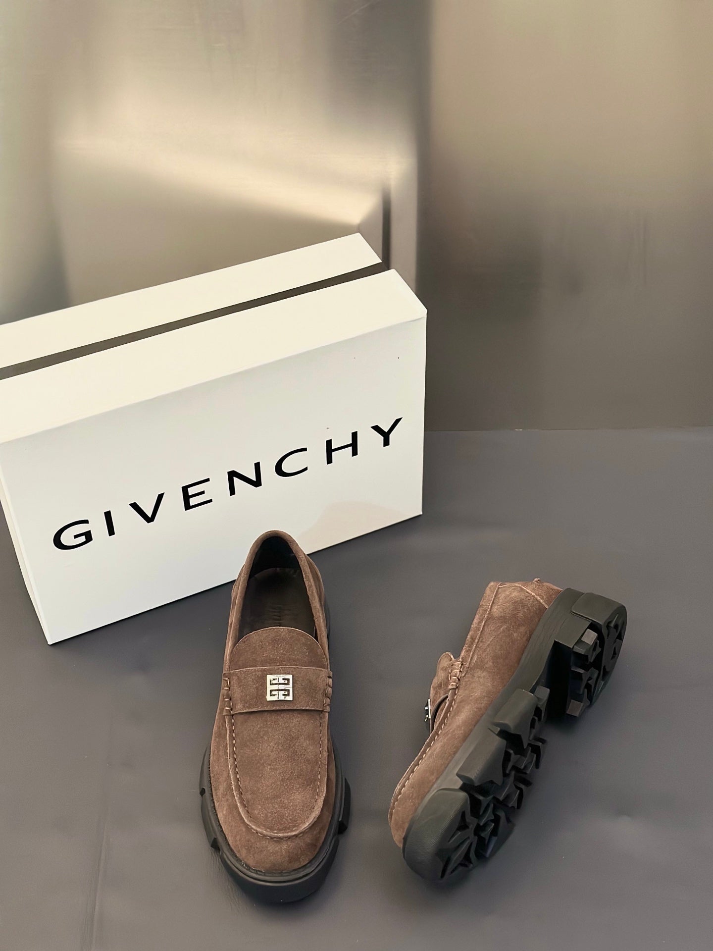 Brown suede loafers shown from side and back with logo plaque strap