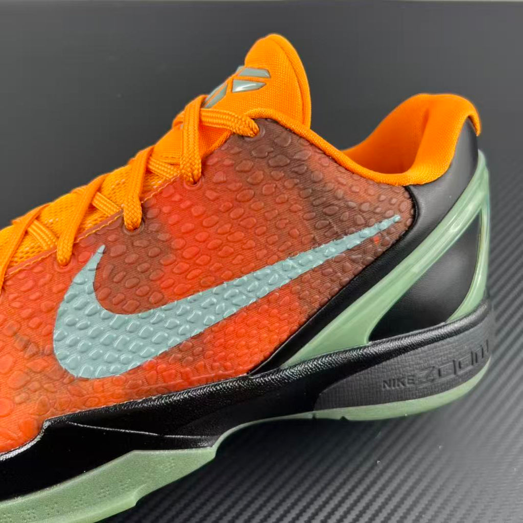 Basketball shoe side profile with orange upper, light blue swoosh, and green sole