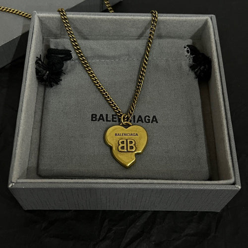 Heart pendant necklace with gold chain and logo heart charm, in a gray box.