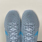 Light blue and gray lace-up basketball shoes with textured toe and laces on top.