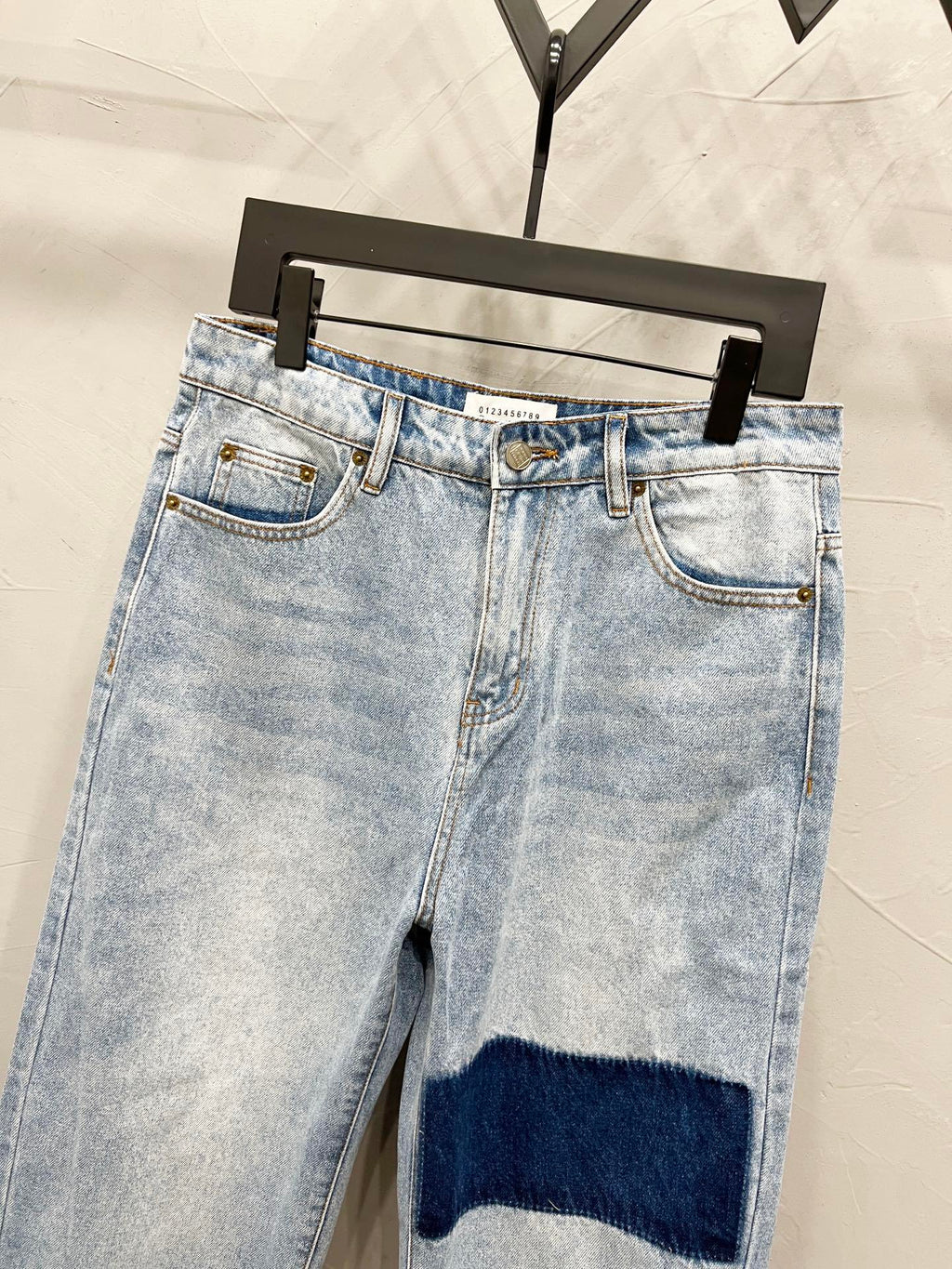 Maison Margiela denim jeans with dark knee stripe patch, front view with belt loops