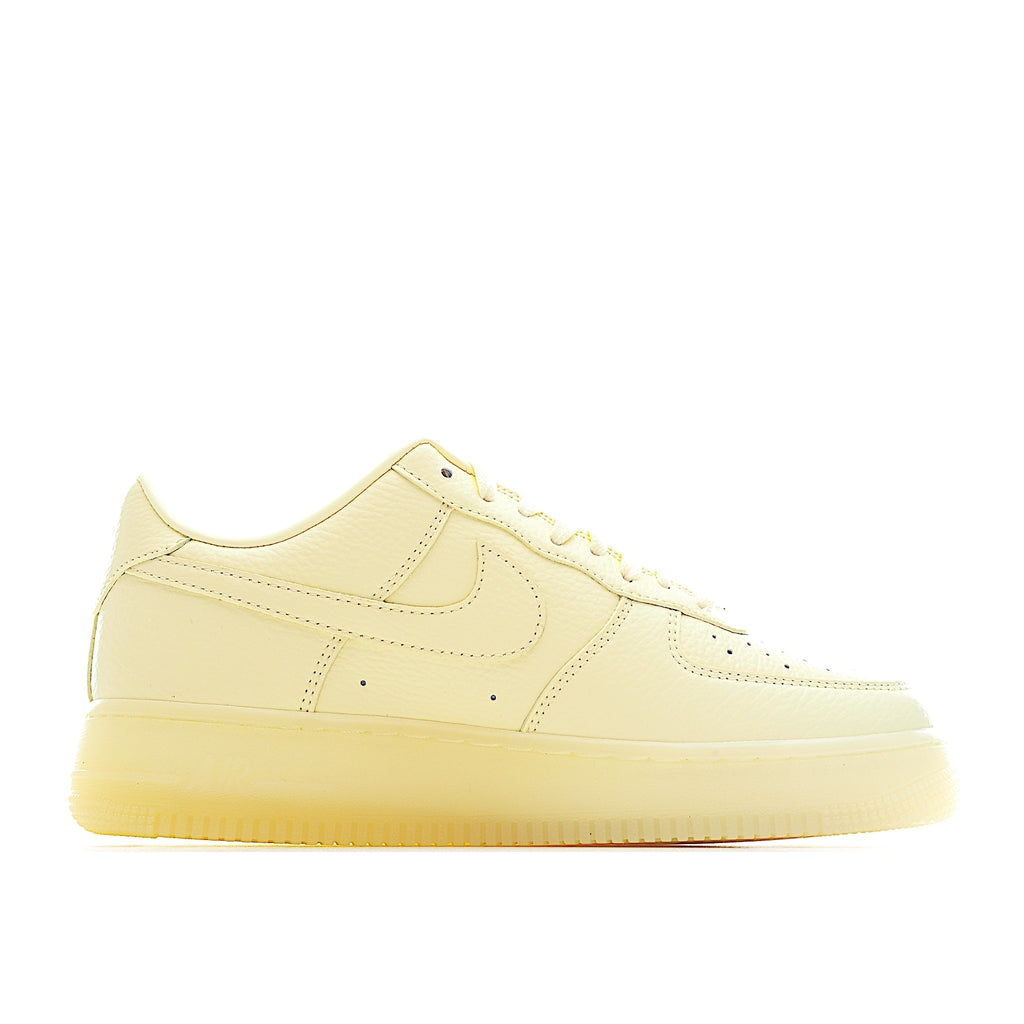 Air Force 1 low-top sneaker in pale yellow leather, front quarter view with perforations