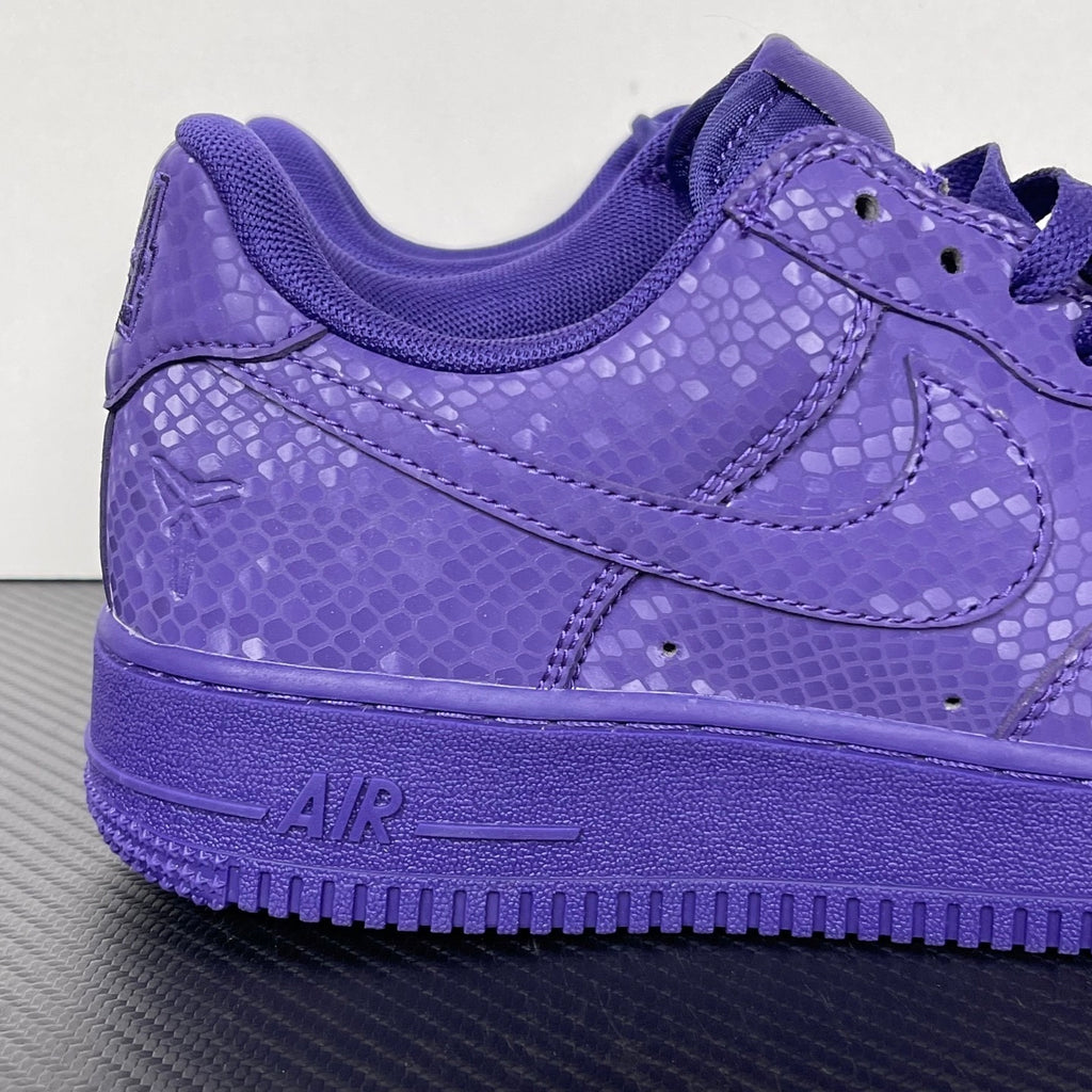 Purple low-top sneakers with swoosh logo, lace-up closure, and cushioned collar
