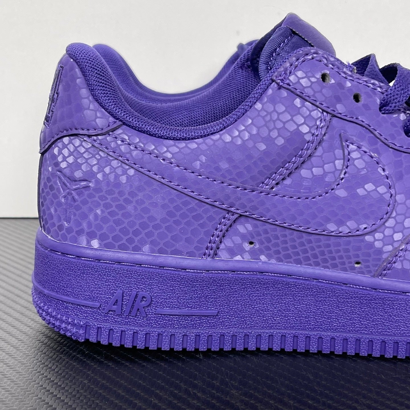 Purple low-top sneakers with swoosh logo, lace-up closure, and cushioned collar