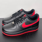 Black low-top sneakers with red swoosh, black laces, and red outsole edge