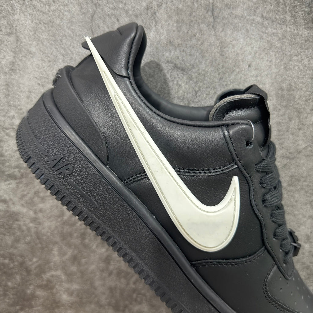 Black leather low-top sneakers with white Nike swoosh and lace-up front