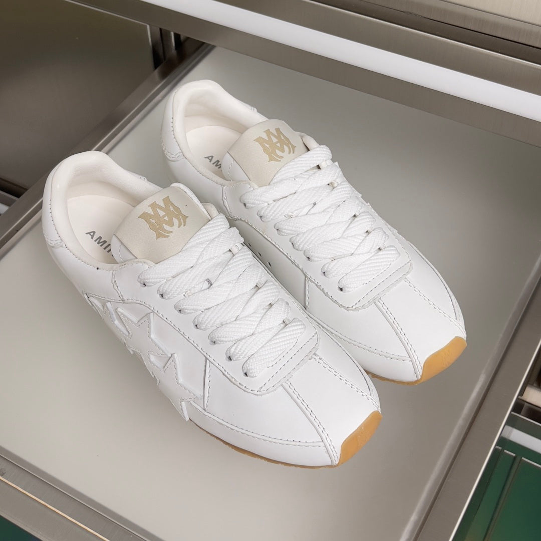 Pair of Amiri white leather sneakers with star motif and white laces on gum soles