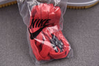 Red and black sneakers in clear bag with NIKE swoosh on upper