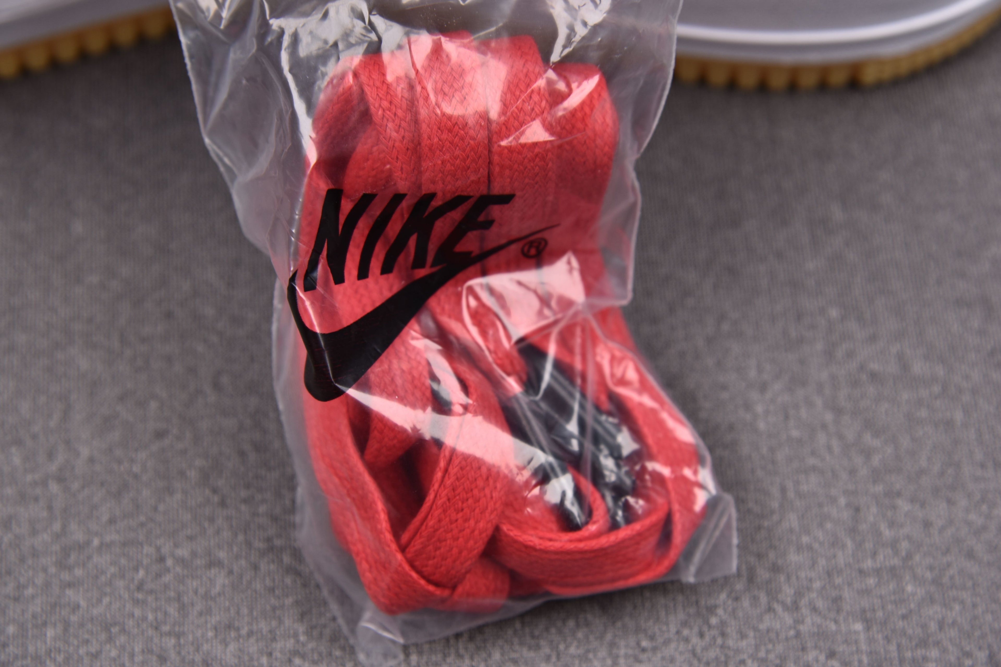 Red and black sneakers in clear bag with NIKE swoosh on upper