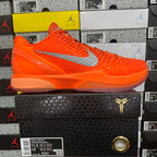 Orange lace-up sneaker with textured upper and gray swoosh
