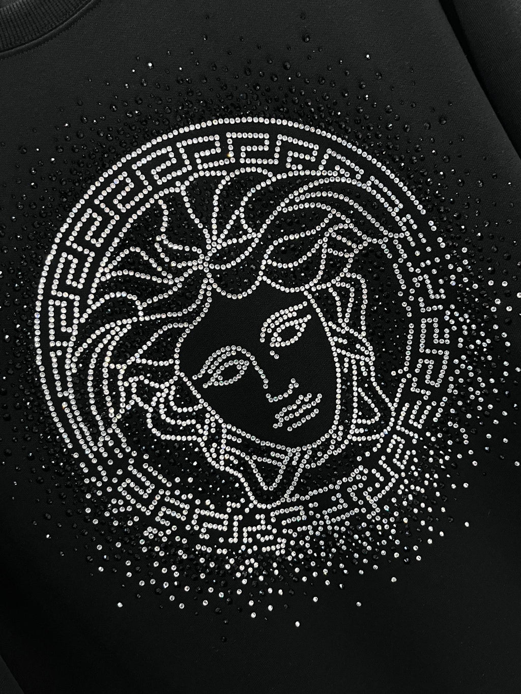 Black crewneck sweatshirt with rhinestone Medusa face graphic