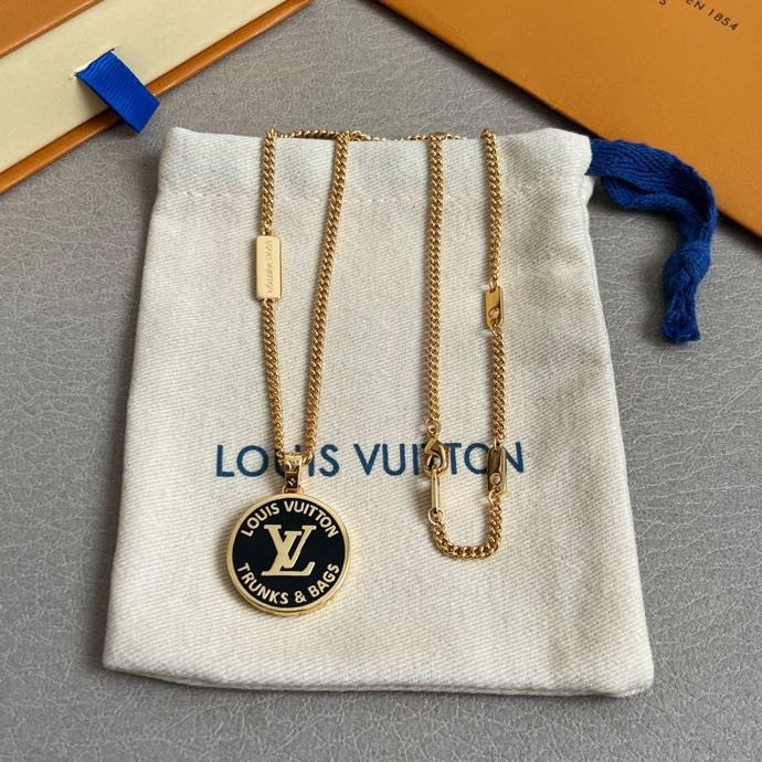 Gold-tone necklace with round logo pendant in a light gray drawstring pouch