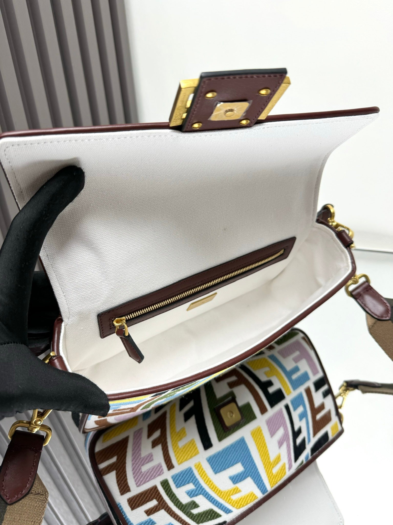 Baguette-style bag open view with leather zipper trim and inner pocket
