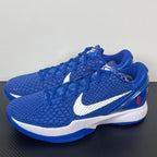 Blue Nike basketball sneakers pair with white swoosh, lace-up design, and midsole