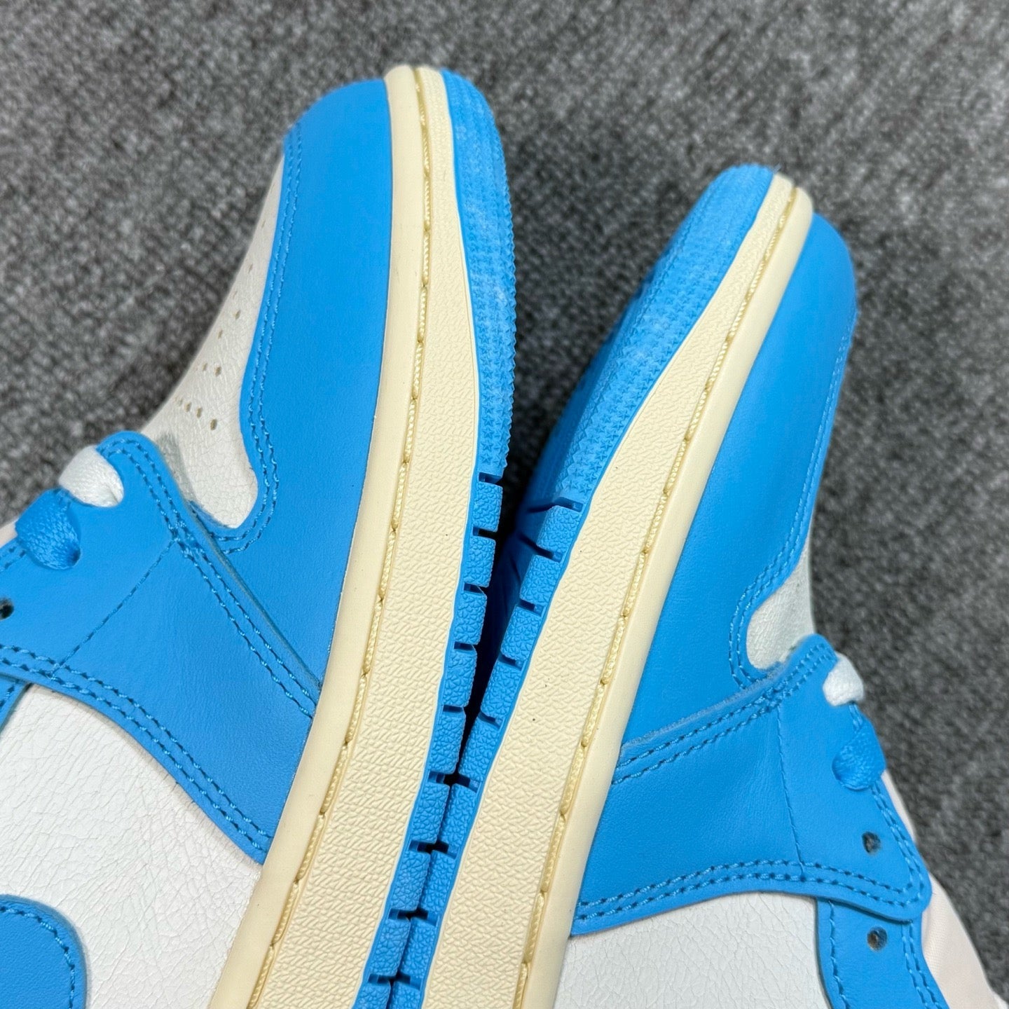 Air Jordan 1 Retro High OG sneakers, side view with cream midsole and blue trim